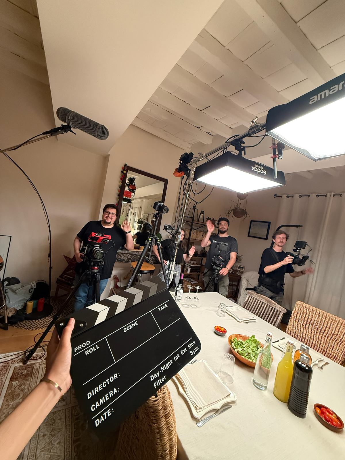Un clap au premier plan, une équipe de tournage derrière.